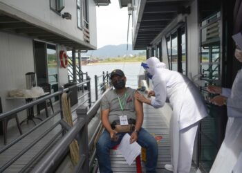 ANTARA penggiat pelancongan yang divaksin dalam program outreach vaksinasi Covid-19 yang diadakan di rumah bot di Tasik Kenyir, Hulu Terengganu hari ini. - UTUSAN/PUQTRA HAIRRY ROSLI