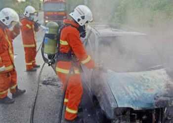 ANGGOTA bomba memadamkan kebakaran sebuah kereta Perodua Kancil di Jalan Changkat Lada-Pasir Salak dekat Pasir Salak hari ini. - FOTO/IHSAN JBPM PERAK