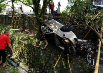 ORANG ramai memberi bantuan kepada pemandu dan penumpang kereta yang terbabas dan terjunam ke dalam parit di Jalan Bakti 2, Taman Mutiara Rini, Johor Bahru. - FOTO/RAJA JAAFAR ALI