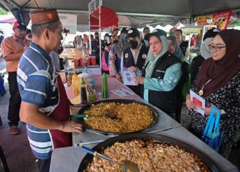 DR. Kasemani Embong (dua, kanan) menasihati peniaga agar sentiasa menjaga kebersihan makanan semasa melakukan pemantauan keselamatan makanan di Bazar Ramadan Gong Badak, Kuala Nerus, semalam. - UTUSAN/PUQTRA HAIRRY ROSLI