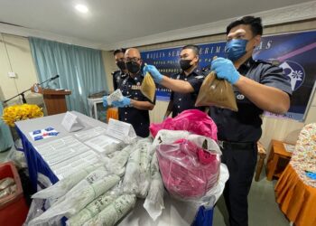 ZAIZUL Rizal Zakaria (tiga dari kanan) bersama pegawainya menunjukkan bungkusan berisi air ketum serta barang rampasan lain dalam sidang akhbar di IPD Pasir Puteh hari ini. - UTUSAN/TOREK SULONG