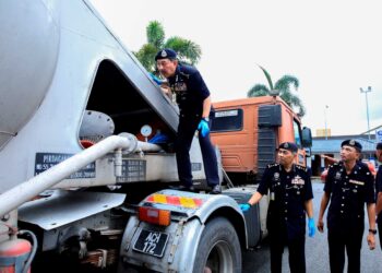 MUHAMAD Zaki Harun memeriksa treler simen yang digunakan untuk menyeludup daun ketum di Batu 6, Batu Melintang, Jeli, semalam. - UTUSAN/KAMARUL BISMI KAMARUZAMAN