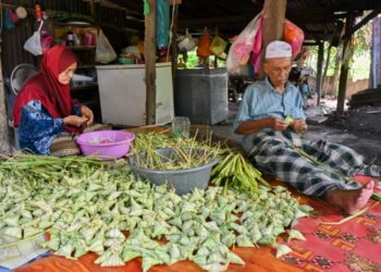 ABDULLAH Mad Amin dan Ramlah Endut tidak menang tangan menyiapkan tempahan ketupat palas sempena sambutan Hari Raya Aidilfitri di Kampung Surau Panjang, Kuala Terengganu, Terengganu. - UTUSAN/PUQTRA HAIRRY ROSLI