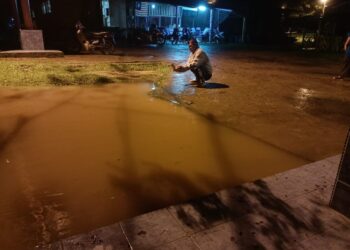 SEORANG penduduk sedang merakamkan gambar air Sungai Tembeling yang mula melimpah masuk di dataran perniagaan Kampung Bantal, Ulu Tembeling di Jerantut, Pahang. - FOTO /IHSAN PENDUDUK KAMPUNG BANTAL