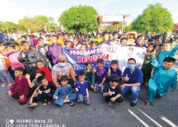 AHMAD Nazlan Idris (duduk depan, tiga dari kiri) dan Dr. Amir Faisal Mohd. Khairi (kanan) menyantuni kanak-kanak dengan bergambar sebelum masuk ke bilik berkhatan di Poliklinik Kesihatan bandar Jerantut, Pahang, baru-baru ini. -UTUSAN/HARIS FADILAH AHMAD