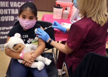 RIHANNA CHIHUAQUE,7, menerima suntikan vaksin Covid-19 di Institut Arturo velasquez di Chicago.-AFP