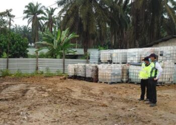DR. Famey Yusof (kanan) melihat lokasi pembuangan sisa kimia yang telah dibersihkan di stor simpanan haram di Kampung Baru, Sengkang, Kulai di Johor.