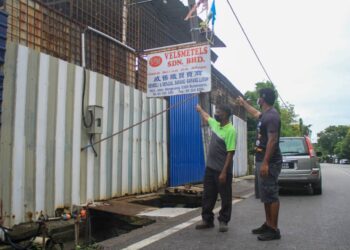 PENGUSAHA barangan terpakai, Mohammad Amin Naim Abdullah (kiri) bersama Mani Kandan'g (kanan) menunjukkan papan tanda kedai mereka di Butterworth, Pulau Pinang yang tidak dibenarkan beroperasi semasa PKP 3.0 menyebabkan mereka menanggung kerugian besar.