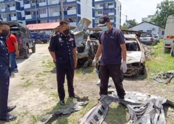 MOHD. Azmir (tengah) melihat kerangka Honda HRV yang terbakar selepas merempuh sebuah rumah di Tumpat, Kelantan, pagi tadi. - FOTO/ROHANA MOHD. NAWI