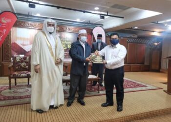 MD. Anizam Abd. Rahman menyerahkan sumbangan al-Quran kepada wakil hotel sambil diperhatikan Abdul Rahman Ibrahim Al-Robian (kiri). - FOTO/ROSALWANI CHE SOH