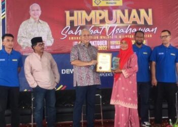 ANNUAR Musa (empat dari kiri) menyampaikan sijil kepada sahabat Amanah Ikhtiar Malaysia (AIM pada Program Himpunan Sahabat Usahawan AIM, Wilayah Kelantan di Kompleks YKK, Melor, Kelantan hari ini. - FOTO/ROSMIZAN RESDI
