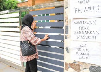NOTIS yang meminta supaya wartawan tidak menemubual keluarga ditampal di pintu pagar rumah Azie di Kampung Semat Jal, Tumpat, Kelantan. – FOTO/KAMARUL BISMI KAMARUZAMAN