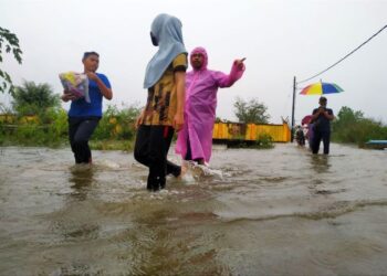 ORANG ramai mengharung air di Pasir Mas yang menjadi jajahan paling teruk terjejas akibat banjir luar jangka di Kelantan kali ini. - FOTO/ZULHANIFA SIDEK