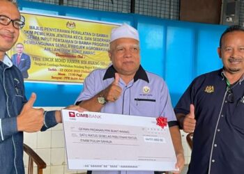 MOHD. Hanifa Awang Su (kiri) menyerahkan replika cek bantuan LPP kepada Pengerusi PPK Bukit Awang, Mohd. Agil Awang (tengah) di Pasir Puteh, Kelantan, hari ini. - FOTO/TOREK SULONG