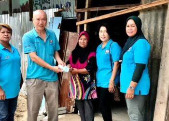 PUI Tiong Lam (dua dari kiri) menyerahkan kutipan wang kepada Siti Nor Mamat (tiga dari kanan) di Kampung Kok Keli, Tumpat, Kelantan, hari ini. - FOTO/ROSLIZA MOHAMED
