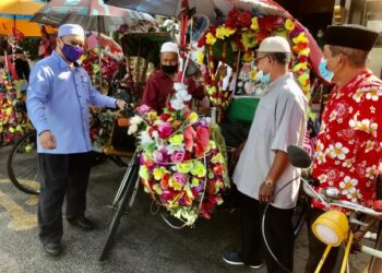 MD. Anizam Ab. Rahman (kiri) berbual dengan pengayuh beca selepas menyampaikan bantuan kepada mereka di Pusat Penerangan Pelancongan Negeri Kelantan, Kota Bharu hari ini. - FOTO/ROSLIZA MOHAMED