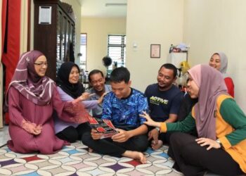 MUHAMMAD Syahril Saidi (tengah) meneliti tawaran yang diterima selepas memperolehi keputusan cemerlang dalam SPM baru-baru ini. - UTUSAN/KAMARUL BISMI KAMARUZAMAN