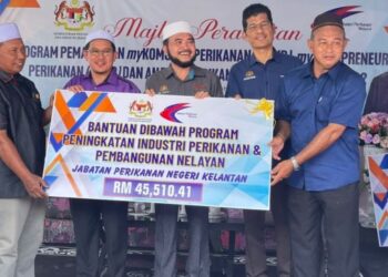 NIK Muhammad Zawawi Salleh (tengah) ketika menyampaikan replika bantuan kepada nelayan di bawah Program Peningkatan Industri Perikanan dan Pembangunan Nelayan di Tok Ajam, Pasir Puteh, Kelantan hari ini. - FOTO/TOREK SULONG