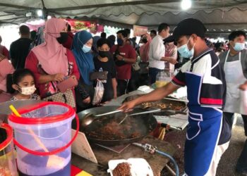 MUHAMAD Saiful Salleh yang kudung sebelah tangan lincah menggoreng mi dan kuetiau di bazar Ramadan di Pusat Sivik, Gua Musang, Kelantan, Kelantan. - FOTO/AIMUNI TUAN LAH