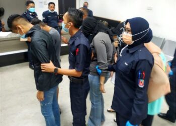 ANGGOTA polis wanita (berbaju kelabu) bersama teman lelaki dan tiga rakan mereka didakwa di Mahkamah Majistret Kota Bharu hari ini kerana memiliki air ketum 2.5 liter, Khamis lalu. - FOTO/ZULHANIFA SIDEK