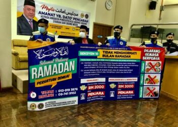 HASNAN Ramli (dua dari kiri) bersama pegawai Jaheaik menunjukkan kain rentang peringatan mengenai kesalahan tidak menghormati Ramadan di bawah Seksyen 10 Enakmen Kanun Jenayah Syariah (1) 2019, di Kota Bharu, Kelantan. - FOTO/ROSLIZA MOHAMED