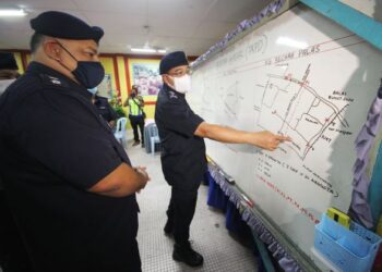 SHAFIEN Mamat  (kanan) menunjukkan kawasan terlibat PKPD semasa taklimat polis di Sekolah Kebangsaan Penggu, Bunut Susu, Pasir Mas, Kelantan. - UTUSAN/ZULHANIFA SIDEK