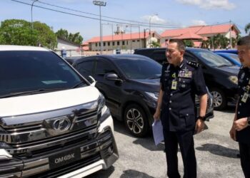 MUHAMMAD Zaki Harun (kiri) bersama anggota memeriksa kenderaan yang digunakan untuk menyeludup PATI semasa sidang akhbar di IPD Kota Bharu, Kelantan hari ini. - FOTO/KAMARUL BISMI KAMARUZAN