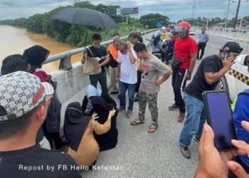 ORANG ramai sedang memujuk seorang wanita yang cuba terjun dari jambatan Sultan Yahya Petra, Kota Bharu, Kelantan. - FOTO/IHSAN FACEBOOK HELLO KELANTAN