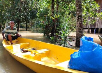 MUSTOPA Hassan menggunakan perahu untuk berulang alik selepas laluan masuk ke Kampung Tersang, Rantau Panjang, Kelantan ditenggelami banjir. - UTUSAN/YATIMIN ABDULLAH