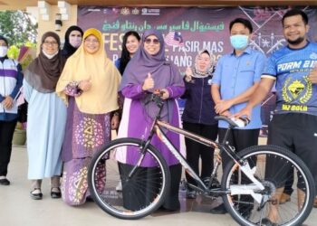 SITI Zailah Mohd. Yusof (dua dari kiri) menyampaikan hadiah cabutan bertuah sebuah basikal kepada pengunjung Festival Jjupo Mato Keluarga Malaysia 2022 di Dataran Bandar Baru Pasir Mas, Kelantan hari ini. - FOTO/ROHANA ISMAIL