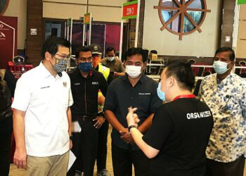 RAHMAD Mariman (dua dari kanan) bersama Lim Ban Hong (kiri) mendengar taklimat daripada petugas PPV Pikas di Bayou Lagoon, Bukit Katil, Melaka. - UTUSAN/DIYANATUL ATIQAH ZAKARYA