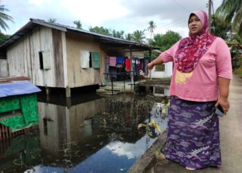 HALIMAH  Bee Vi Kamaluddin  menunjukkan keadaan rumahnya yang ditenggelami air bertakung sejak sebulan lalu di Kampung Hutan Pasir, Kelantan hari ini.