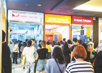 Orang ramai beratur untuk menukar wang dengan penggurup wang di di Pusat Beli Belah Midvalley Megamall ketika nilai ringgit terus jatuh berbading dolar Amerika Syarikat. – MINGGUAN/AMIR KHALID