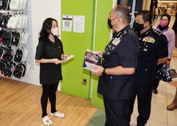 MIOR Faridalathrash Wahid (kanan) mengedarkan risalah cegah jenayah kepada orang ramai pada Kempen Pencegahan Jenayah Komersial (Jenayah Dalam Talian) Tahun 2021 di Ipoh hari ini. - UTUSAN/ZULFACHRI ZULKIFLI
