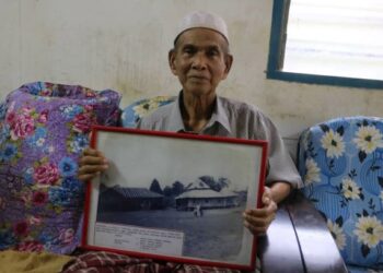 OTHMAN Tawang menunjukkan gambar Madrasah Al-Aliah Al Arabiah di Kampung Bohor di Bera, Pahang ketika menjadi tenaga pengajar di situ setelah tamat pengajian Madrasah Al Junid Singapura. - UTUSAN/SALEHUDIN MAT RASAD