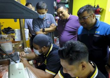 Norazlan Anuar (berdiri, tiga dari kanan) melihat proses membuat barangan kemas di Kilang Pertukangan Emas dan Perak Makmur Gold di Jalan Temenggong, Kota Bharu, semalam. – UTUSAN/ZULHANIFA SIDEK