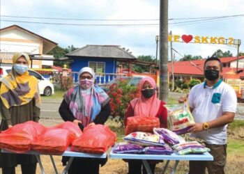 MOHD JUSNI Yusof (kanan) bersama sebahagian guru dan barang keperluan dapur untuk bantuan kepada penduduk yang memerlukan secara 'pandu dan lalu' di
Felda Kota Gelanggi Dua di Jerantut, Pahang. - UTUSAN/HARIS FADILAH AHMAD
