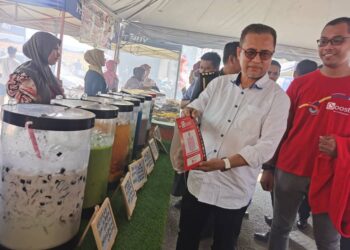 AZMAN ISMAIL (dua dari kiri) menunjukkan QR kod yang disediakan oleh penjual air di Bazar Ramadan Rahmah di Stadium Sultan Muhammad IV, Kota Bharu, Kelantan-UTUSAN/ROSALWANI CHE SOH