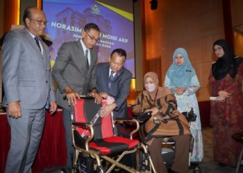 ALEXANDER Nanta Linggi (tengah), dan Timbalan Menteri Perdagangan Dalam Negeri dan Hal Ehwal Pengguna, Datuk Rosol Wahid (dua dari kiri), berbual dengan kakitangan KPDNHEP yang menerima sumbangan kerusi roda kerana menghidap panyakit strok, Norasima Mohd Arif pada Majlis Perhimpunan Bulanan KPDNHEP Julai 2022, di Menara SSM, di sini hari ini. -UTUSAN/ SHIDDIEQIIN ZON