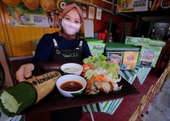 NURSHUHADA Yaacob menunjukkan set Nasi Buluh Ayam Tulang Rapuh jualannya ketika ditemui Utusan Malaysia di KewBuluh Cafe, Jalan Batu 8, Telok Kemang, Port Dickson, semalam. – UTUSAN/MOHD. SHAHJEHAN MAAMIN.