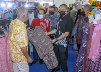 MOHD. Yusri Mohd. Yusoff (tengah) melihat produk baju yang 
dihasilkan pengusaha kraf pada Majlis Perasmian Festival Kraf@
Perak 2022 di Dataran Menara Condong, Teluk Intan, kelmarin.
– UTUSAN/MUHAMAD NAZREEN SYAH MUSTHAFA