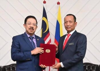 MOHD. Zuki Ali  (kiri) menyerahkan watikah lantikan sebagai Ketua Setiausaha Kementerian Pendidikan kepada Nik Nasarudin Mohd. Zawawi. 