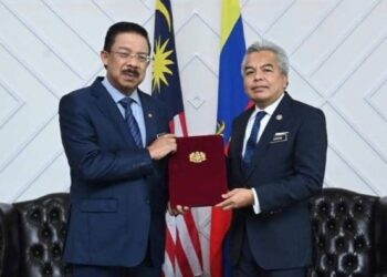 MOHD. Zuki Ali (kiri) menyampaikan watikah pelantikan kepada Amran Mohamed Zin sebagai Ketua Setiausaha Kementerian Luar di Putrajaya hari ini. - IHSAN WISMA PUTRA