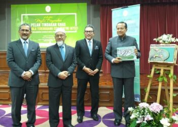 AHMAD Samsuri Mokhtar (kanan) menunjukkan dokumen Pelan Tindakan Khas Muara KTCC pada majlis penyerahan pelan tindakan itu kepada tujuh agensi teknikal di Kuala Terengganu,  hari ini. - UTUSAN/KAMALIZA KAMARUDDIN