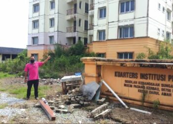 AHMAD Zahir Abdul Razak menunjukkan semak samun yang memenuhi kawasan Kuarters Institusi Pendidikan Felda Sungai Tiang di Mukim Padang Kerbau, Pendang, Kedah. - UTUSAN/OTHMAN YAHAYA