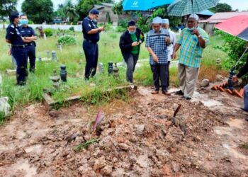 SHEIKH Ahmad Faisol Omar (dua dari kanan) dan anggota polis memeriksa kubur yang didakwa mengandungi cecair merah di Tanah Perkuburan Islam di Masjid Al Irfan, Derga, Alor Setar, semalam.