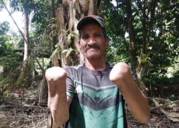 ABDUL Halim Ali yang kudung kedua-dua pergelangan tangan akibat bom buatan sendiri semasa berusia 13 tahun mampu melakukan pelbagai kerja seperti insan biasa. – UTUSAN/NOOR HAYATI MAMAT