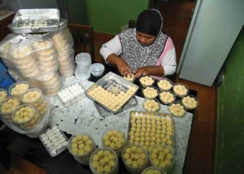 AZEANI Abu Seman menyiapkan tempahan putu kacang dan putu beras untuk pelanggan sempena Aidilfitri di Kampung Seberang Ramai, Kuala Perlis. – UTUSAN/IZLIZAN OTHMAN