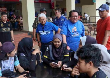 TENGKU Adnan Tengku Mansor beramah mesra bersama golongan muda semasa turun padang di Medan Selera Presint 16 di Putrajaya. - UTUSAN/FAISOL MUSTAFA