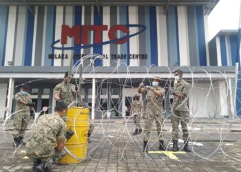 ANGGOTA tentera darat memasang kawat duri di sekitar PKRC MITC di Ayer Keroh, Melaka. - UTUSAN/MUHAMMAD SHAHIZAM TAZALI